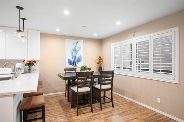 dining area with light wood-style floors, baseboards, and recessed lighting