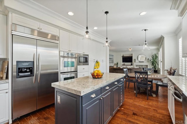 kitchen featuring built in appliances, white cabinets, open floor plan, ornamental molding, and dark wood-style floors