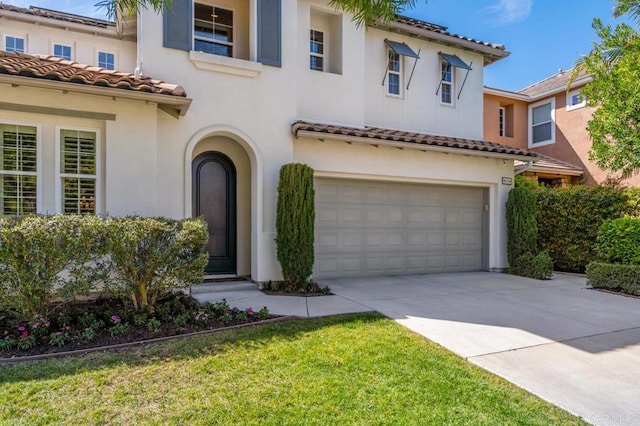 mediterranean / spanish-style home featuring driveway, a tiled roof, a garage, and stucco siding