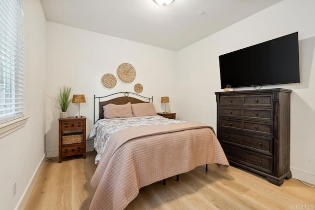 bedroom featuring light wood-style floors and baseboards