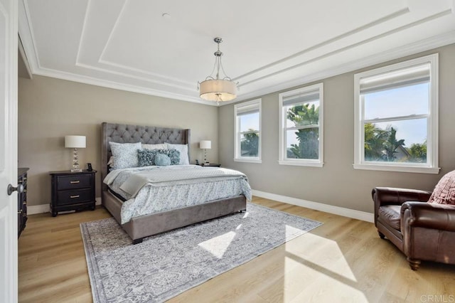 bedroom featuring baseboards, crown molding, and light wood finished floors