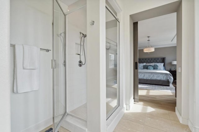 ensuite bathroom featuring a shower stall, connected bathroom, ornamental molding, and tile patterned flooring