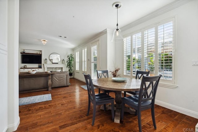 dining room with ornamental molding, hardwood / wood-style flooring, and baseboards