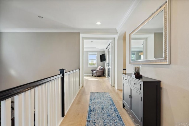 hallway featuring light wood finished floors, baseboards, crown molding, and recessed lighting