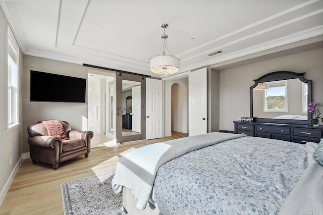 bedroom featuring arched walkways, crown molding, visible vents, light wood-style floors, and baseboards