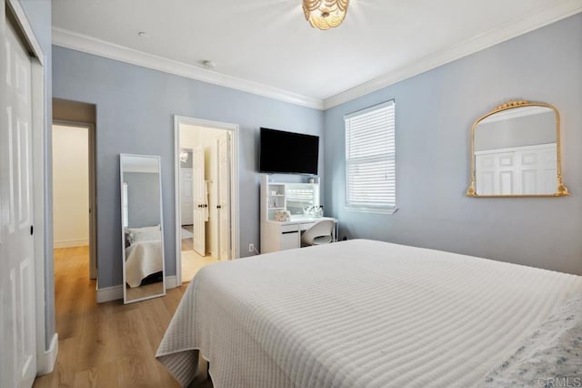 bedroom with baseboards, a closet, wood finished floors, and crown molding