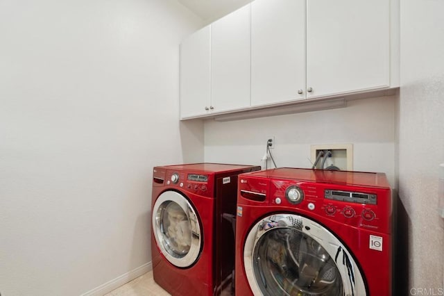 laundry area with washing machine and dryer, cabinet space, and baseboards