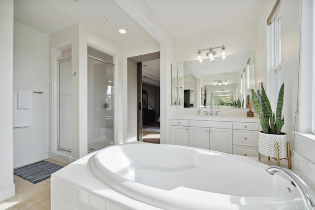 full bath featuring a garden tub, a shower stall, tile patterned floors, and vanity