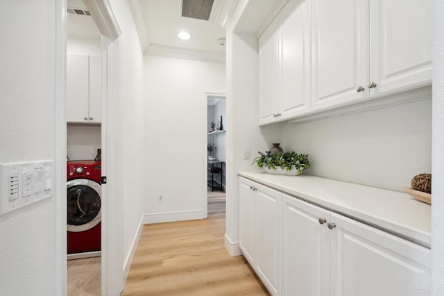 laundry room with visible vents, light wood-type flooring, cabinet space, washer / clothes dryer, and crown molding