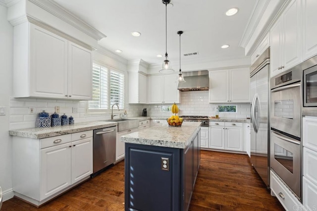 kitchen with wall chimney exhaust hood, appliances with stainless steel finishes, crown molding, white cabinetry, and a sink