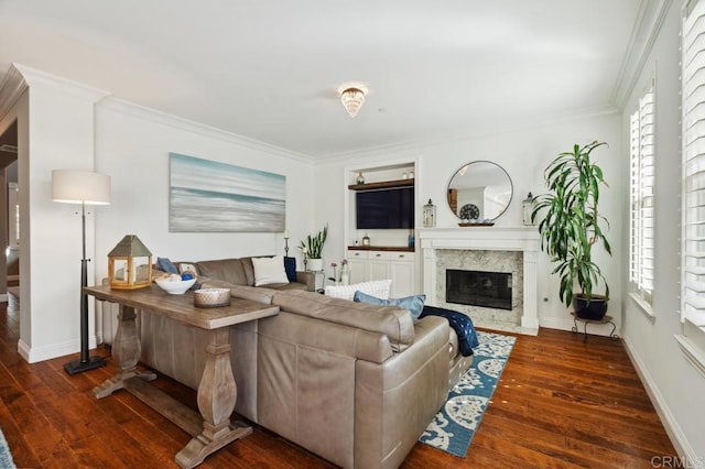 living area with hardwood / wood-style flooring, baseboards, ornamental molding, and a high end fireplace