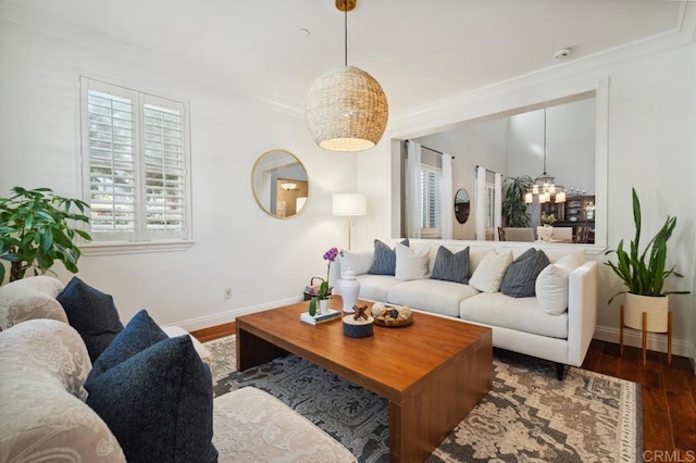 living area featuring baseboards, an inviting chandelier, wood finished floors, and crown molding