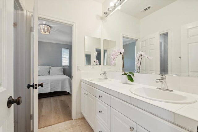 full bathroom featuring double vanity, visible vents, a sink, and tile patterned floors