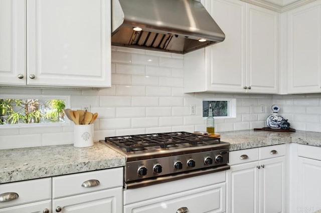 kitchen with white cabinetry, stainless steel gas cooktop, under cabinet range hood, and decorative backsplash