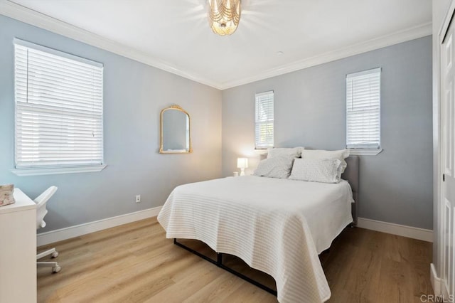 bedroom with crown molding, wood finished floors, and baseboards