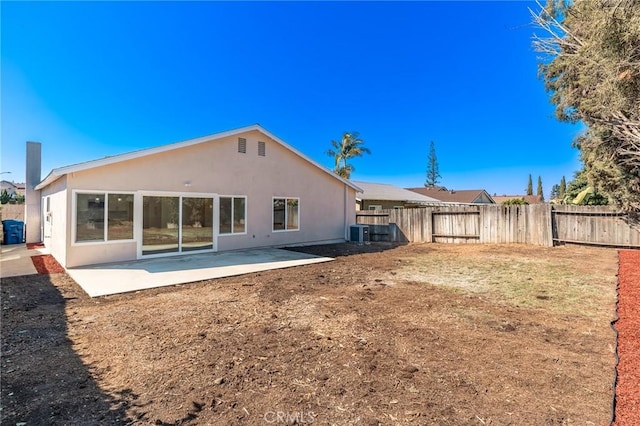 back of property with a patio, central AC, fence, a lawn, and stucco siding