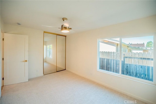 unfurnished bedroom featuring a closet, carpet flooring, and a ceiling fan