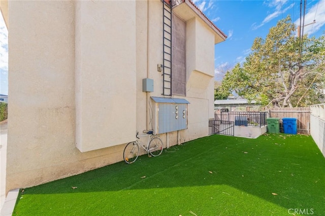 exterior space with a tiled roof, fence, a lawn, and stucco siding