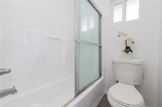 full bathroom featuring toilet and bath / shower combo with glass door