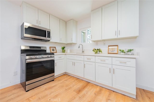 kitchen with white cabinets, appliances with stainless steel finishes, and light countertops