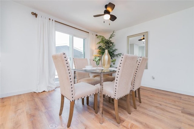 dining area with light wood finished floors, ceiling fan, and baseboards