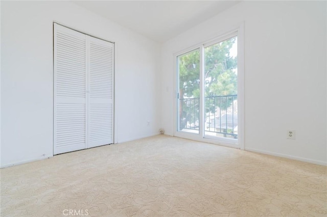 unfurnished bedroom featuring access to outside, a closet, and carpet