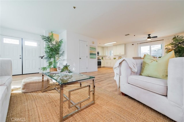 living room with visible vents and light wood-style flooring