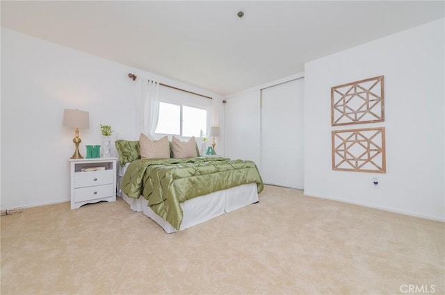 bedroom with a closet and light colored carpet