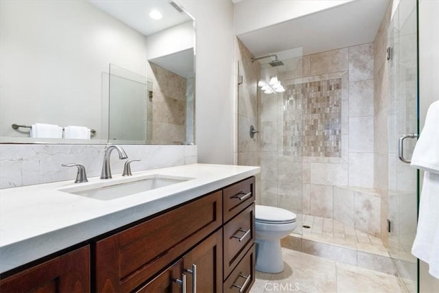 bathroom with toilet, vanity, and a shower stall