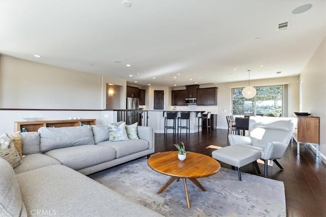 living area featuring dark wood-type flooring, recessed lighting, visible vents, and baseboards