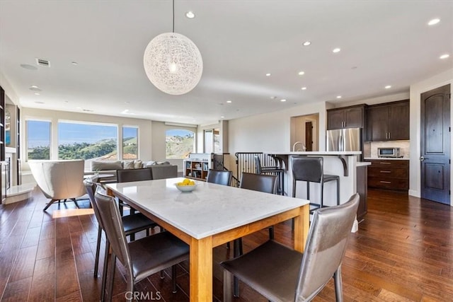 dining space with dark wood-style floors, visible vents, and recessed lighting