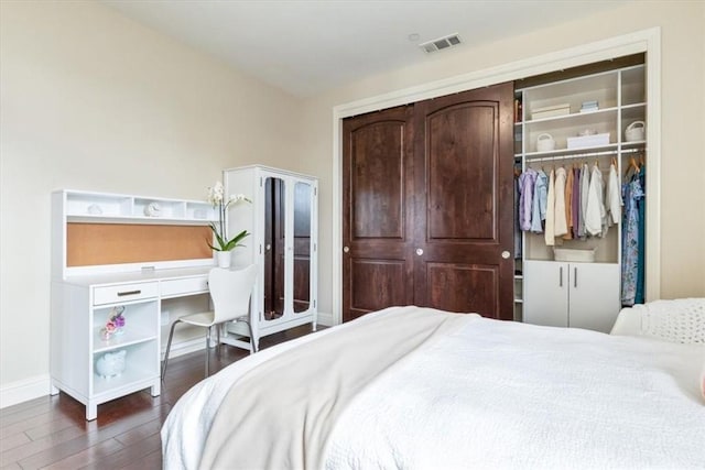 bedroom with dark wood-style floors, a closet, visible vents, and baseboards