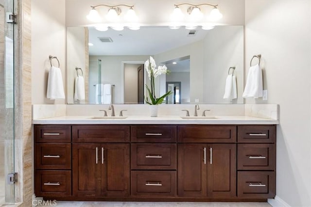 full bath with double vanity, visible vents, and a sink