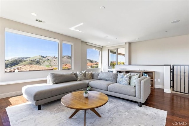 living room featuring dark wood finished floors, recessed lighting, visible vents, a mountain view, and baseboards