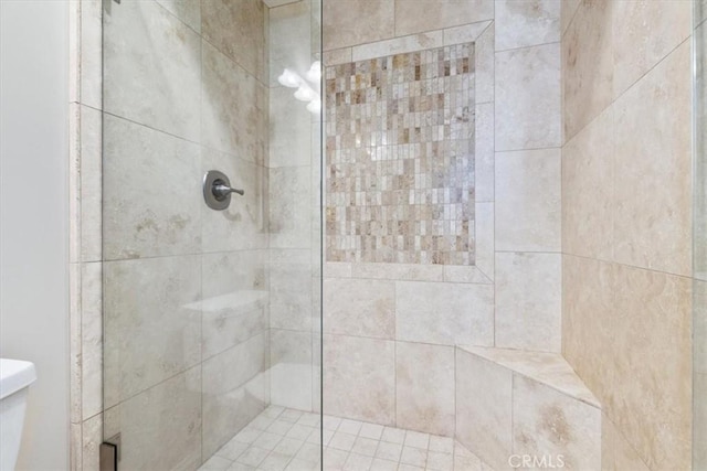 bathroom with a stall shower and toilet