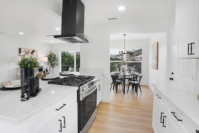 kitchen featuring island exhaust hood, visible vents, light wood-style floors, gas range, and plenty of natural light