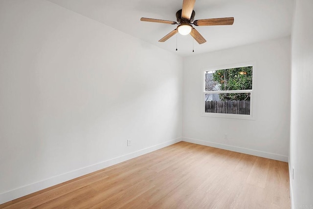 spare room with light wood-type flooring, ceiling fan, and baseboards