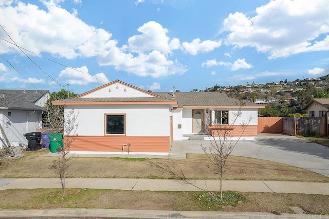 ranch-style home featuring fence and stucco siding