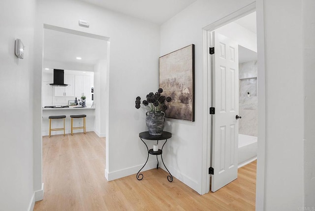 hallway with baseboards and light wood finished floors