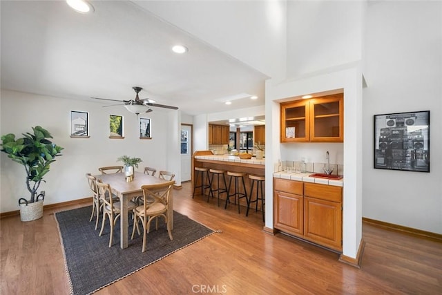 dining space with ceiling fan, baseboards, and wood finished floors