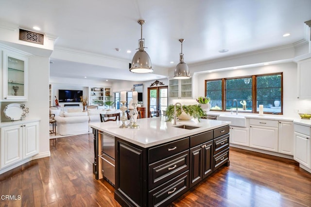 kitchen with light countertops, white cabinetry, a sink, and crown molding