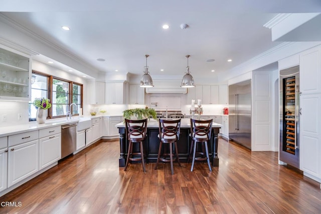 kitchen with a sink, white cabinetry, a center island with sink, and stainless steel appliances