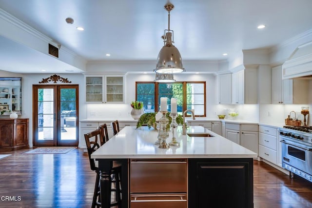 kitchen with dark wood-style flooring, plenty of natural light, luxury stove, and light countertops