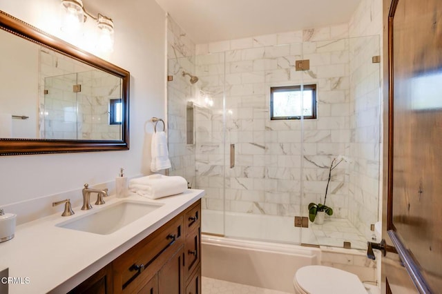 full bathroom with toilet, vanity, and bath / shower combo with glass door