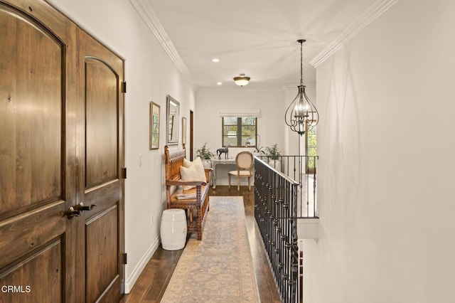 corridor with baseboards, ornamental molding, a chandelier, an upstairs landing, and dark wood finished floors