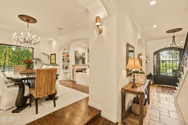 dining area with a chandelier, plenty of natural light, arched walkways, and ornamental molding