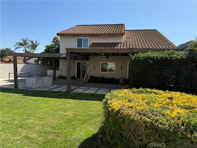 back of house with a patio, a tile roof, an outdoor living space, a lawn, and stucco siding