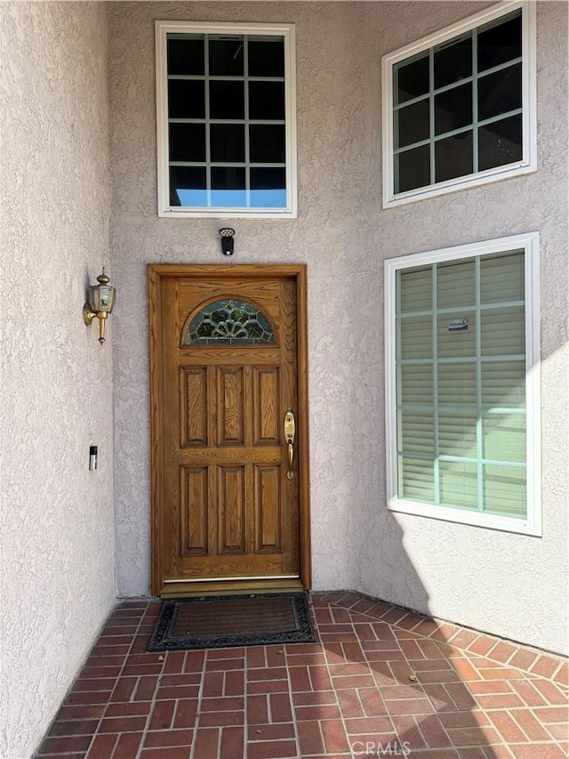 view of exterior entry with stucco siding