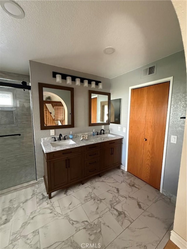 bathroom with marble finish floor, a sink, and visible vents