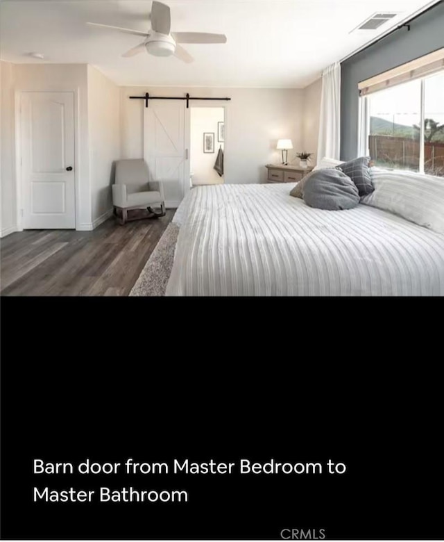 unfurnished bedroom with dark wood-type flooring, visible vents, ceiling fan, and a barn door